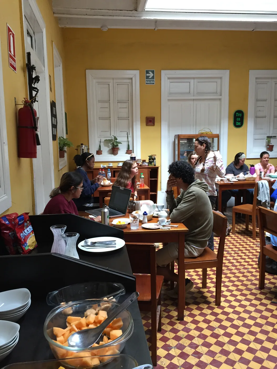 Guests having breakfast in the caf&eacute;-bar room, with the fruit served on the counter