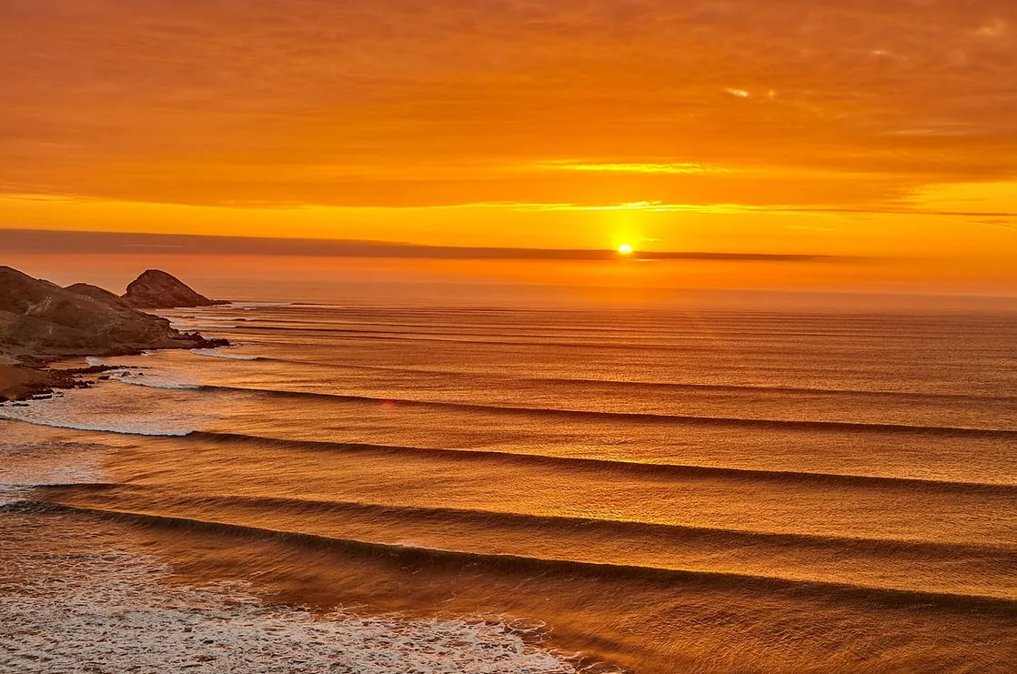 Surfer inside the left at Chicama, with the town behind