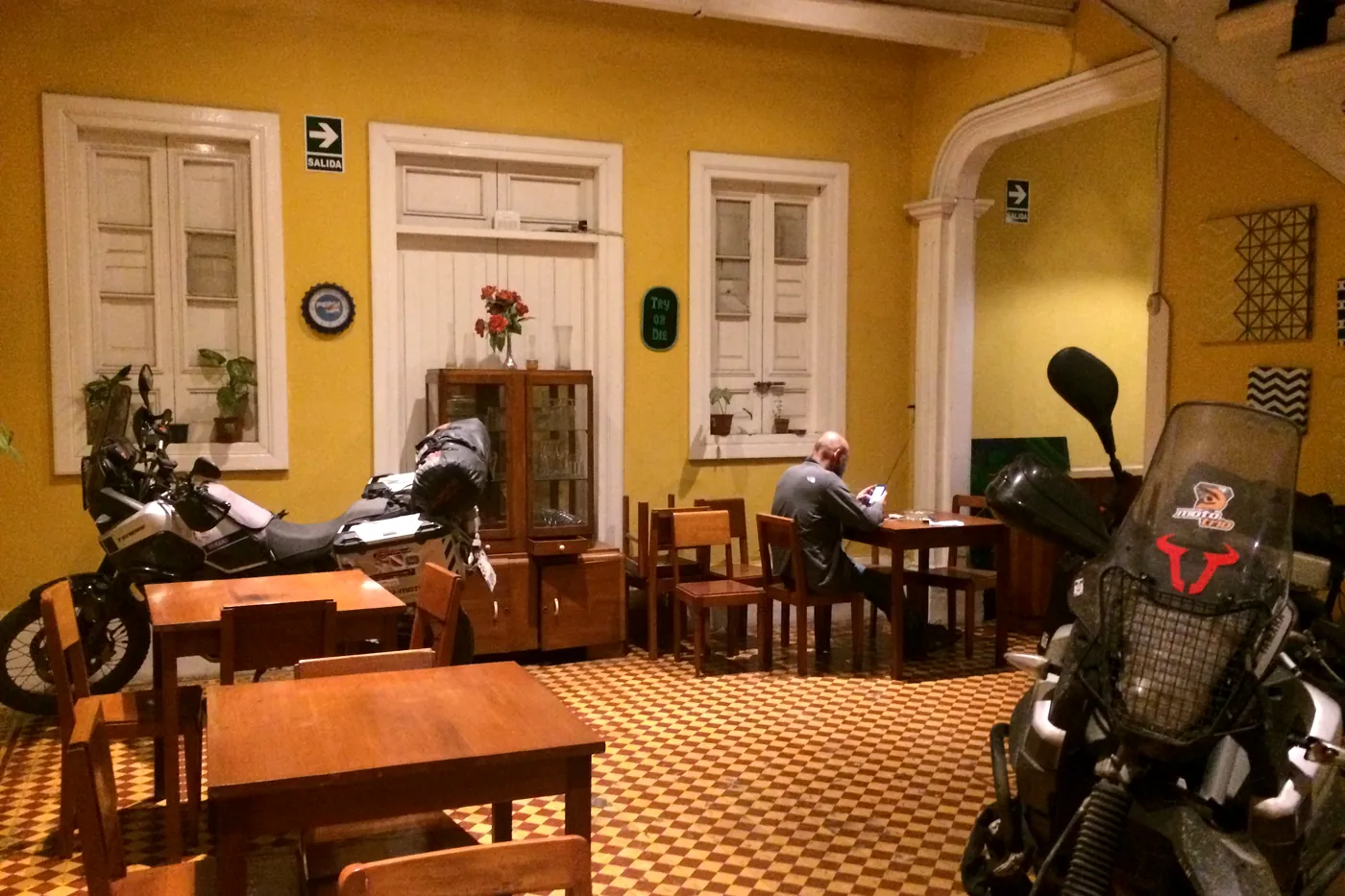 Travel motorbikes parked inside the dining room of the old house, next to the tables