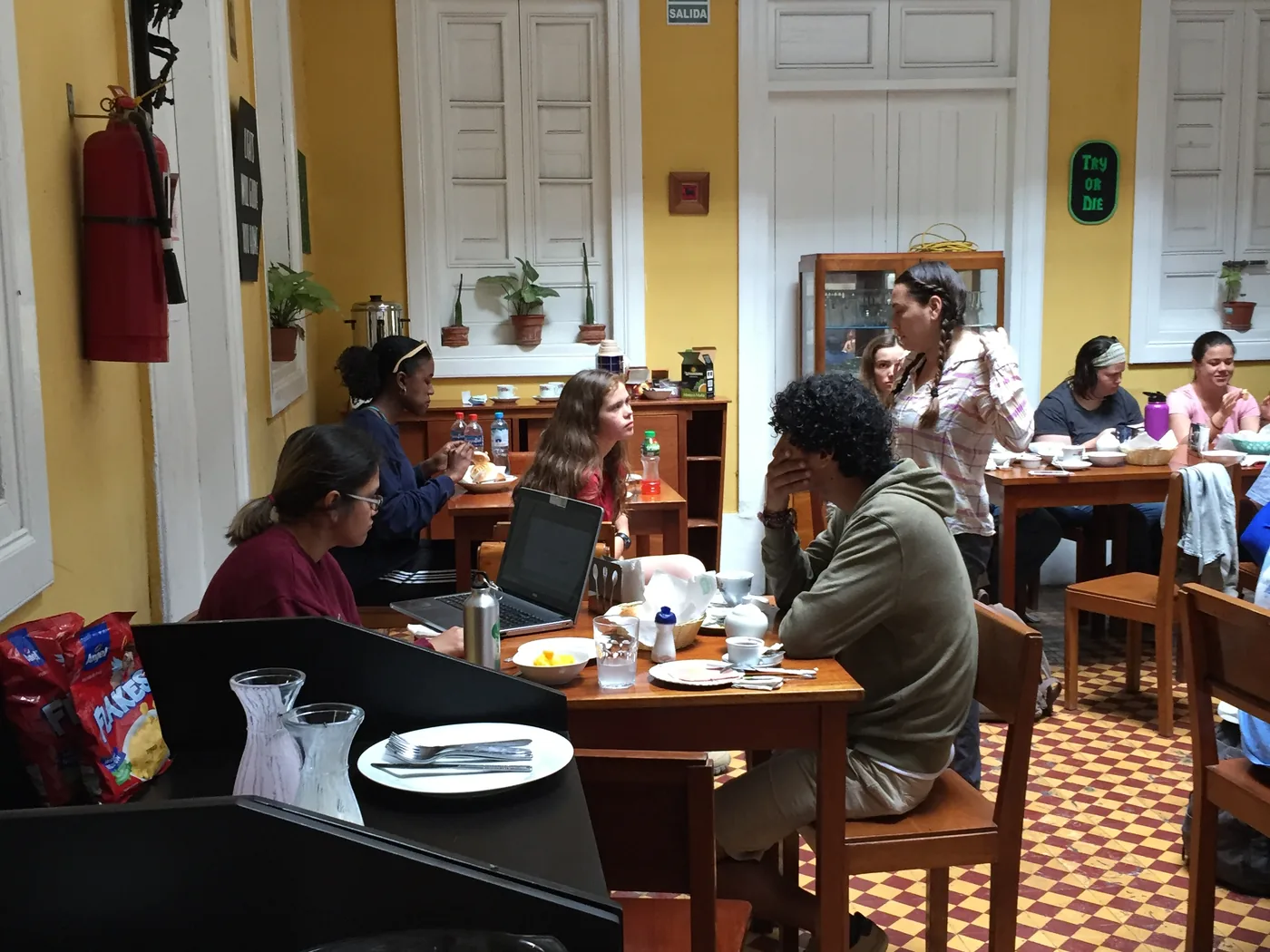 The group having breakfast in the caf&eacute;-bar room, with the chequered floor