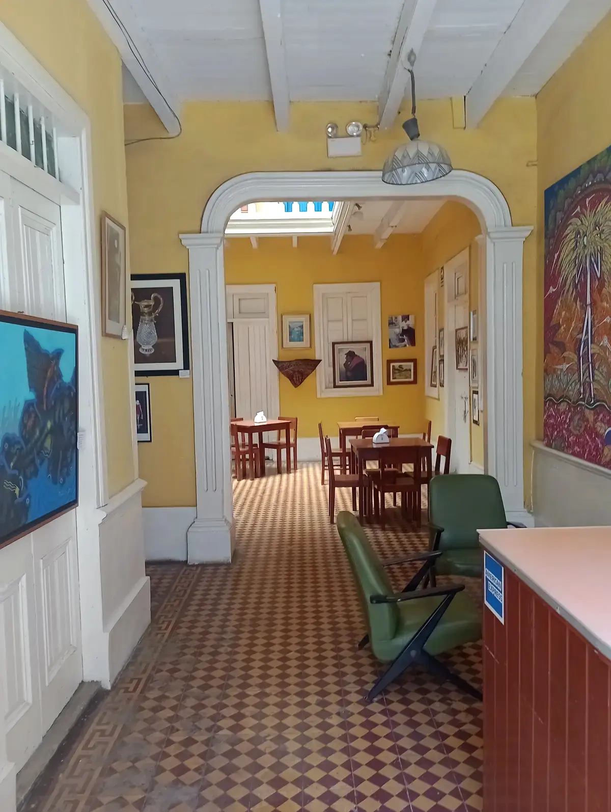 Pasillo de la casona, con el arco, el piso de losa original y el comedor al fondo