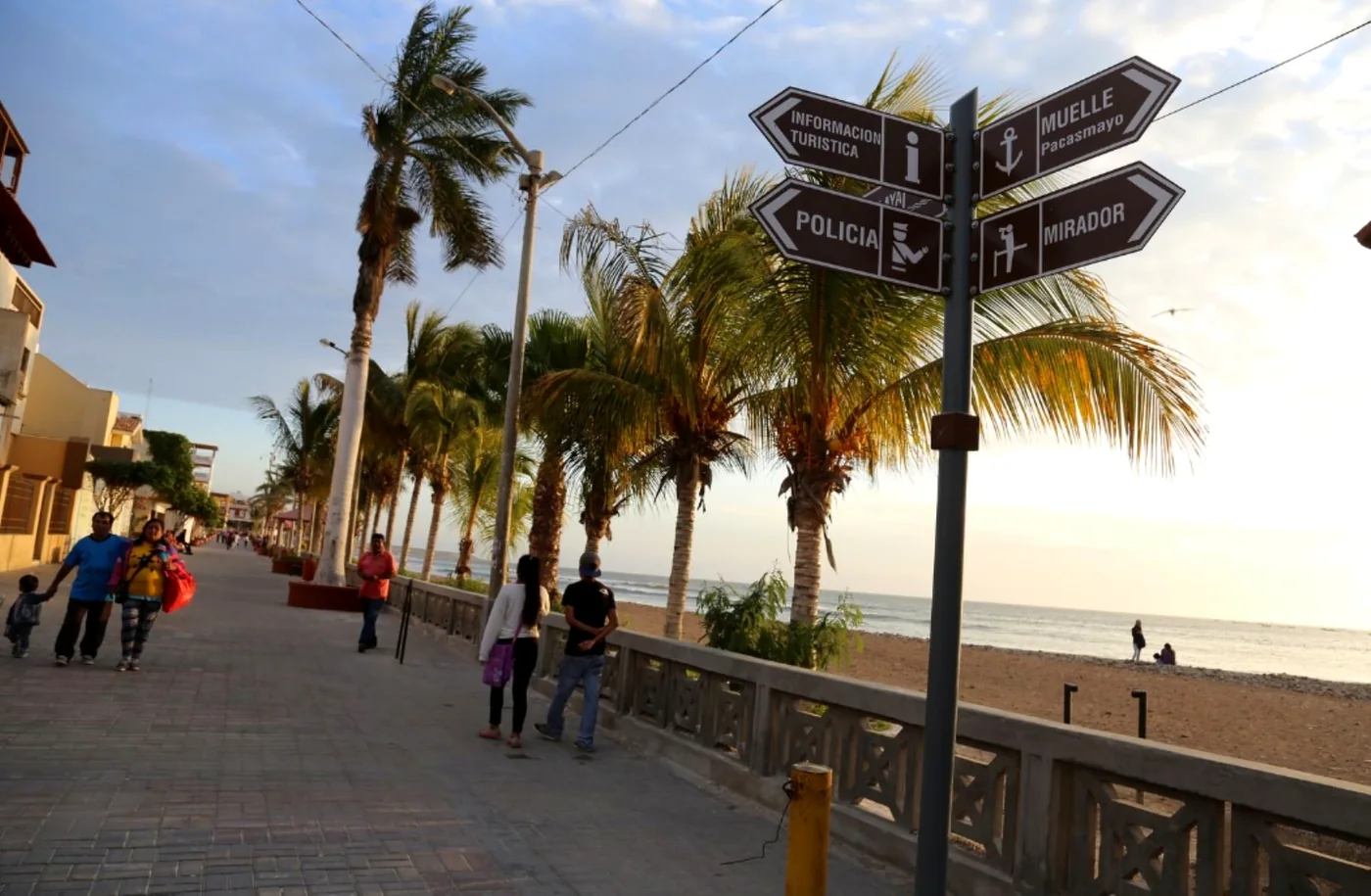 The town seafront with its palm trees and the sign to the pier