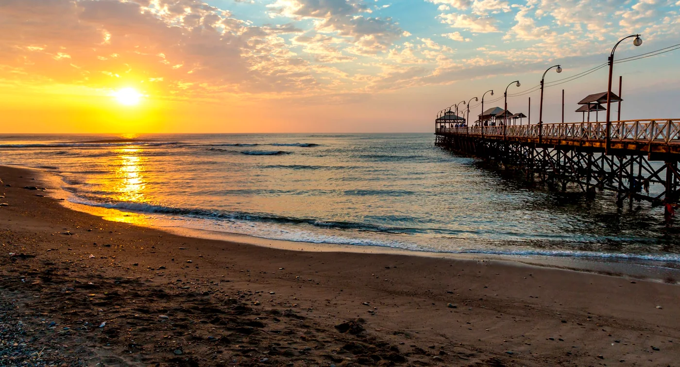 The wooden pier of Pacasmayo at sunset, seen from the sand