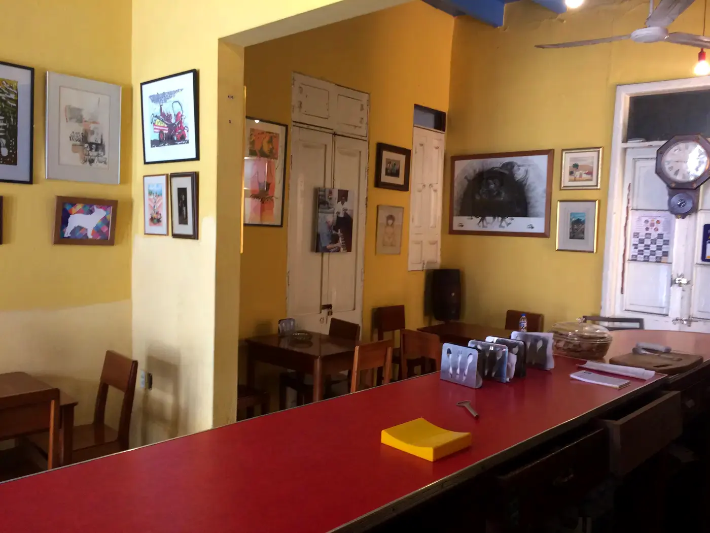 El salón del Al Pacino Café-Bar, con la mesa larga y los cuadros en la pared