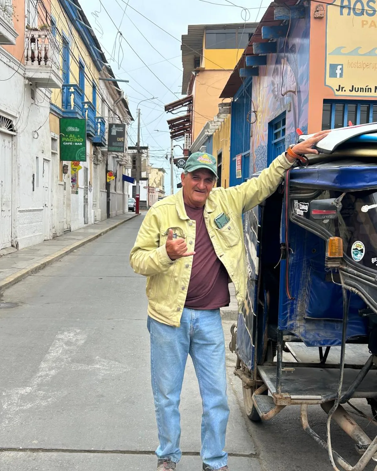 Tato Saavedra junto a su mototaxi con las tablas encima, en Jr. Junín, frente al Al Pacino