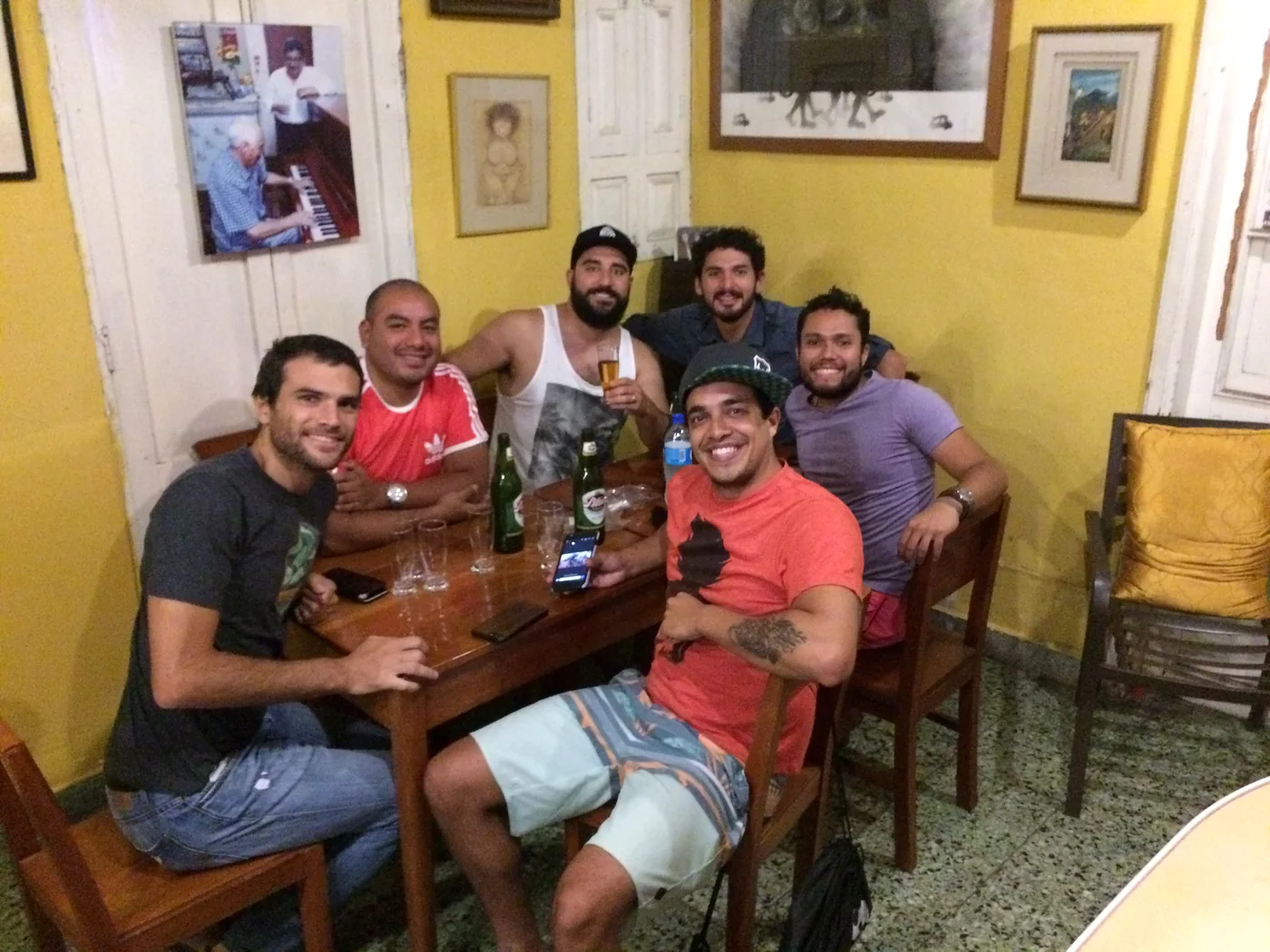 A group of friends with beers at the caf&eacute;-bar table, at night