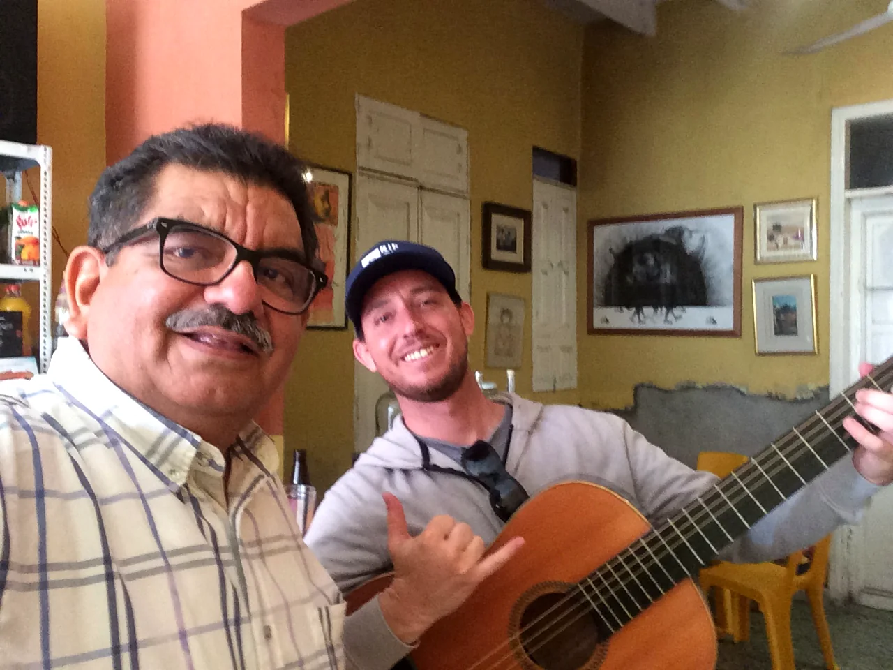 Two guests playing guitar in the sitting room of the old house